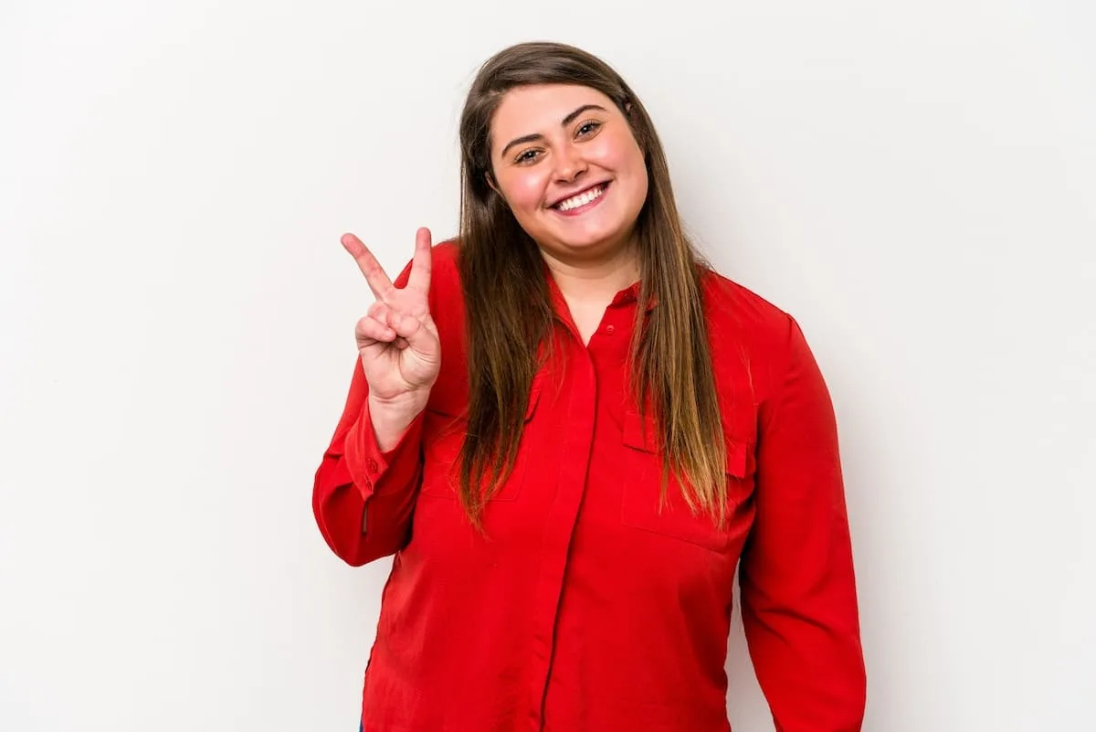 young-caucasian-overweight-woman-isolated-white-background-showing-victory-sign-smiling-broadly maria-andreina-alvarez-TBS-taxes-contabilidad-carolina-del-norte-agente